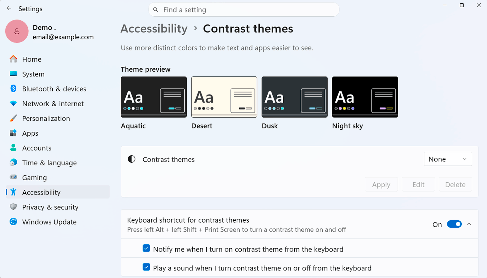 Contrast themes in Windows 11 Settings. A theme preview row shows four built-in themes, Aquatic, Desert, Dusk and Night sky, above a picker set to None with Apply, Edit and Delete buttons beside it.